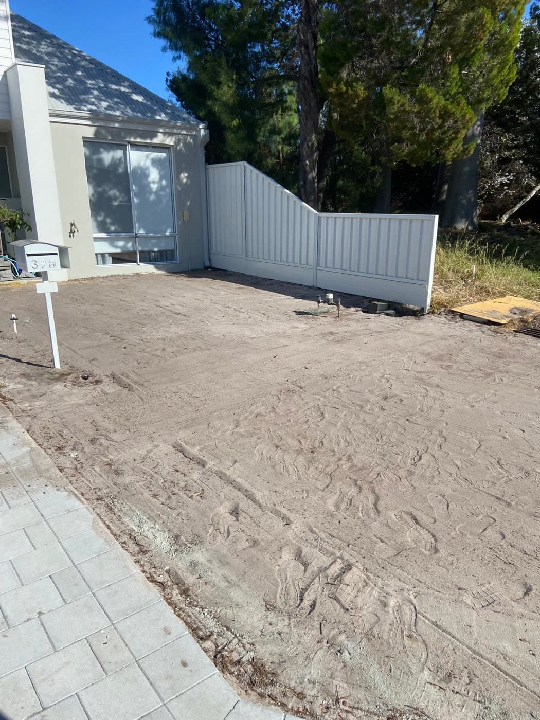 Yard backfilled and graded level with sprinkler heads set.