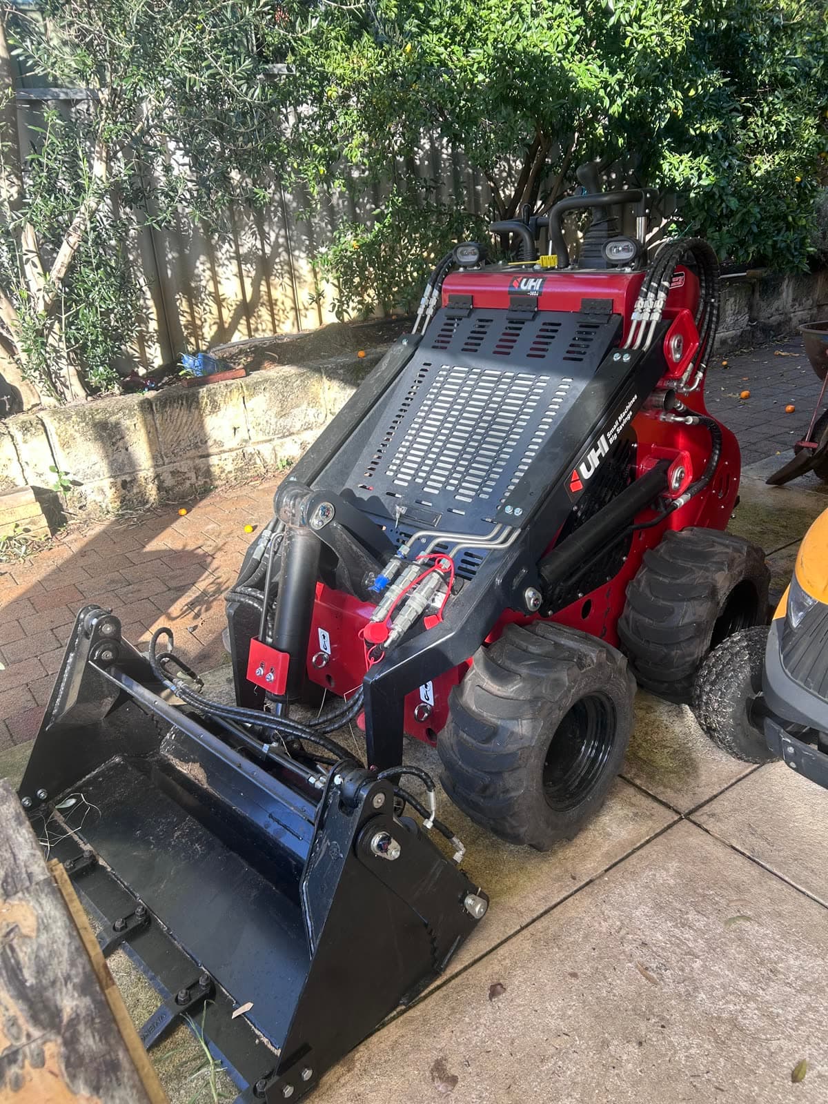 UHI mini loader and operator ready for site work.